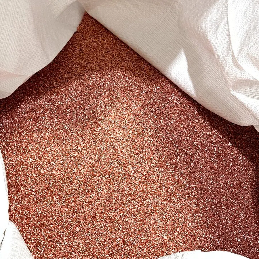 Kupfergranulat fällt aus der Rinne in einen Big-Bag